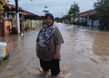 SALAH seorang penduduk meredah banjir yang berlaku di Jalan Balau, Taman Desaru Utama pagi tadi.