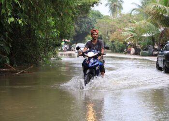 SEORANG penduduk menggunakan motosikal untuk meredah banjir bagi memeriksa keadaan rumahnya yang ditenggelami air di Kampung Tersang, Rantau Panjang, Kelantan-UTUSAN/KAMARUL BISMI KAMARUZAMAN.