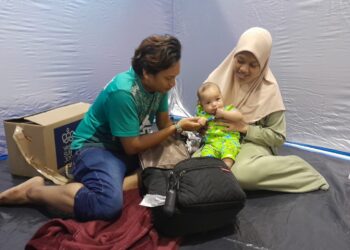 FARAHAIN bersama suami dan bayinya ketika ditemui di PPS Dewan Muafakat TDU hari ini.
