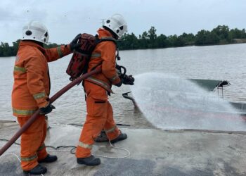 ANGGOTA bomba melakukan kerja-kerja memadamkan kebakaran bot semasa latihan di Jeti Jabatan Laut Kelantan, Tok Bali di Pasir Puteh, Kelantan hari.-UTUSAN/TOREK SULONG.