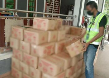 Pegawai KPDN Kelantan memeriksa kotak-kotak minyak masak yang dirampas di sebuah rumah di Kampung Longgel Lemal, Pasir Mas, Kelantan-UTUSAN/IHSAN KPDN KELANTAN.