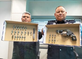 MOHD Nasaruddin M. Nasir (kanan) bersama Pegawai Pemerintah Batalion 9 PGA Kuala Terengganu Supritendan Mannadzar Nasir menunjukkan pistol serta  peluru yang dirampas semasa sidang media di IPD Pasir Mas, Kelantan  hari ini-UTUSAN/ROHANA ISMAIL.