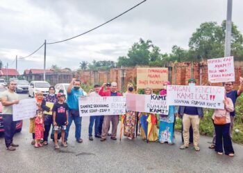 SEBAHAGIAN pembeli rumah teres dan banglo berkembar berkumpul mendesak pemaju menyiapkan rumah mereka di Kampung Mengabang Kapal, Batu Rakit, Kuala Nerus, semalam. – utusan/TENGKU DANISH BAHRI TENGKU YUSOFF