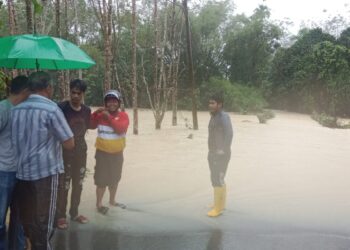 PENDUDUK meninjau limpahan air sungai di jambatan Kampung Binjai - Kemahang di Labok, Machang, Kelantan hari ini.-UTUSAN/ROSMIZAN RESDI.