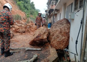 BATU besar yang jatuh bersama runtuhan tanah di jalan belakang sebuah bank di Raub, Pahang hampir menyebabkan satu unit bangunan rumah kedai musnah. -UTUSAN IHSAN JBPM PAHANG