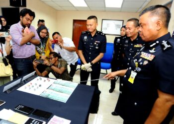 KAMARUL Zaman Mamat menunjukkan  sembilan biji balutan mampat dalam bentuk barrel berisi dadah yang disembunyikan dalam bahagian seluar dalam orang kena tuduh (OKT) dan menelannya semasa berada di Kompleks Mahkamah, Johor Bahru pada sidang media di IPK, Johor Bahru disini.- UTUSAN/RAJA JAAFAR ALI