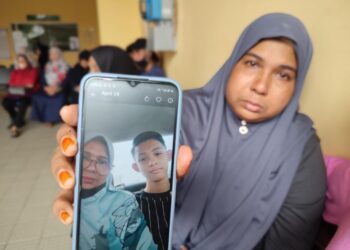 SAFINAH Zakaria menunjukkan gambar kenangan bersama Muhammad Izani Mohd. Tuah yang maut kemalangan di Sungai Petani. 
– UTUSAN/NUR SYAZWANA MANSOR