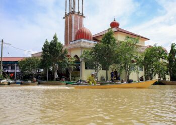PENDUDUK kampung mengunakan bot untuk pergi menunaikan solat jumaat di Masjid Ittihadi Mukim Kubang Sawa, Pengkalan Kubor, Tumpat, Kelantan-UTUSAN/KAMARUL BISMI KAMARUZAMAN