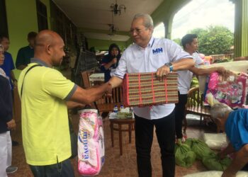 ANNUAR Musa (kanan) menyampaikan sumbangan kepada mangsa banjir di Kampung Sri Kulim, Melor, Kelantan. UTUSAN/ROSMIZAN RESDI.