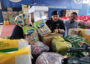 MUHAMAD Zaki Harun (dua kanan) melihat sebahagian barangan bantuan kepada mangsa banjir yang disampaikan pihak Econsave dan ATP Foods Malaysia di IPK Kelantan hari ini-UTUSAN/ROSALWANI CHE SOH