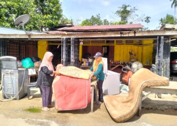 PENDUDUK mula mengemas kawasan rumah mereka selepas ditenggelami banjir di Kampung Serongga, Pasir Mas, Kelantan hari ini-UTUSAN/ROHANA ISMAIL