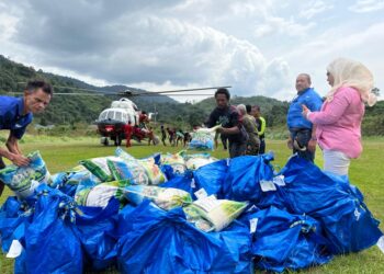 AB. Aziz Yusoff (dua kanan) bersama Roslina Bun membantu menghantar bekalan makanan kepada Orang Asli di Pos Gob, Gua Musang, Kelantan.-UTUSAN/AIMUNI TUAN LAH