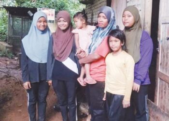 NURUL Wahida Kamaruddin sedang mendukung Nurul Aishah bersama Nurul Syafinaz (dua dari kiri) yang mengalami sakit saraf dan Nurul Shafiera (kiri) mengalami sakit jantung di Felda Kota Gelanggi Dua 
di Jerantut, Pahang. – UTUSAN/HARIS FADILAH AHMAD