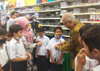AHIMMAT Mydin membantu murid Sekolah Kebangsaan Gadong Jaya, Seremban memilih pakaian sekolah pada Program Jelajah Generasi Pintar Mydin di Mydin Seremban 2, Seremban hari ini.-UTUSAN/NOR SHAFAWATI YUP.