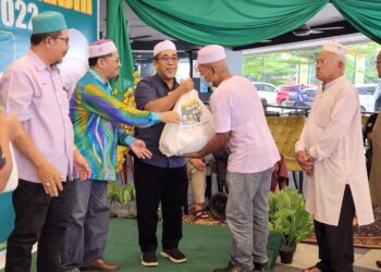 ABD. Rahman Yunus (tengah) menyampaikan bantuan disumbangkan oleh sebuah pasaraya kepada mangsa-mangsa banjir di Tunjung, Kota Bharu, Kelantan hari ini-UTUSAN/MUSTAQIM MOHAMED