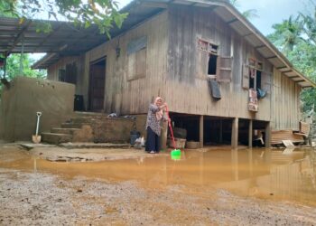 PENDUDUK mula membersihkan kawasan rumah masing-masing yang ditenggelami banjir di Kampung Tersang, Rantau Panjang, Kelantan hari ini-UTUSAN/ROHANA ISMAIL
