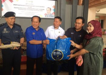 AHMAD Maslan (dua kiri) menyerahkan bantuan kepada mangsa banjir di Pejabat Tanah dan Jajahan Machang, Kelantan hari ini-UTUSAN/ROSMIZAN RESDI