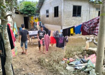 PENDUDUK mula kembali ke rumah masing-masing untuk membersih kesan banjir di Kampung Serongga, Pasir Mas, Kelantan-UTUSAN/ROHANA ISMAIL.