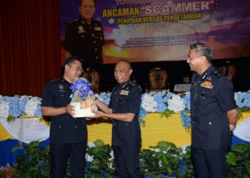 MOHD. Roze Shaari (tengah) menyampaikan cenderahati kepada Asisten Superintenden Rahmat Fitri Abdullah selaku moderator Town Hall PDRM Kedah di Dewan Tunku Ibrahim, IPK Kedah, Alor Setar.