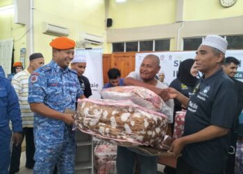 AB Kadir Jailani Baharuddin (kanan) menyampaikan sumbangan tilam nipis kepada mangsa banjir di masjid Kampung Lubok Gong Rantau Panjang, Kelantan. - UTUSAN/ROHANA ISMAIL