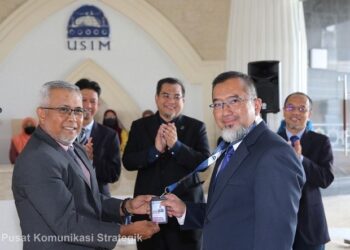 PENDAFTAR USIM, Datuk Muhammad Haizuan Rozali (kiri) menyerahkan kad Timbalan Naib Canselor kepada Muhammad Tauffik sambil disaksikan oleh Sharifudin (tengah) dan pengurusan tertinggi universiti pada majlis ringkas yang diadakan di lobi Canselori USIM, Nilai, Seremban.