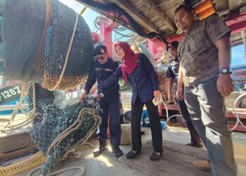 YAZEEREEN A. Bakar (tengah) menunjukkan pukat tunda yang dirampas ekoran penahanan empat buah vessel tempatan yang menceroboh kawasan tangkapan ikan dalam sidang akhbar di Batu Maung, Pulau Pinang hari ini. - UTUSAN/IQBAL HAMDAN