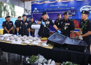 MUHAMAD Zaki Harun (tiga kanan) bersama pegawainya menunjukkan dadah yang di rampas menerusi sekatan jalan raya yang dilakukan oleh JPJ di Laloh, Kuala Krai, Kelantan.-UTUSAN/KAMARUL BISMI KAMARUZAMAN