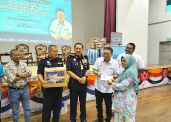 Muhamad Zaki Harun (tengah) bersama Pengarah RHB Bank Berhad Pantai Timur Yusof NG (dua kiri) menyampaikan bantuan kepada mangsa banjir di IPD Pasir Mas, Kelantan hari ini-UTUSAN/ROHANA ISMAIL