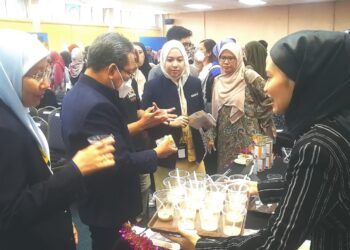 FARIDA Zuraina Mohd. Yusof (kiri) melihat produk berasaskan ubi yang disediakan oleh peserta pertandingan inovasi produk baharu di Fakulti Sains Gunaan UiTM di Shah Alam, Selangor. - UTUSAN / ABDUL RAZAK IDRIS