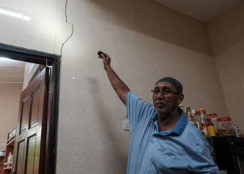 MANSOR Ayed menunjukkan kesan retak dialami rumahnya di Kampung Pantai Tengkera, Melaka. - UTUSAN/SYAFEEQ AHMAD