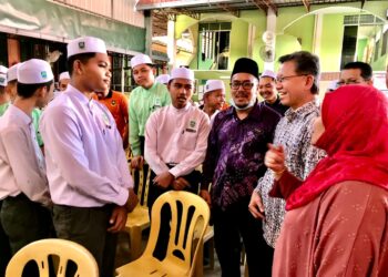 SAID Sidup (dua kanan) berbual dengan pelajar pada majlis Bantuan Pasca Banjir Sempena Kembali Ke Sekolah di SMU (A) Nurul Huda, Tumpat, Kelantan hari ini.- UTUSAN/ROSLIZA MOHAMED