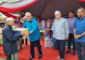 HAMZAH Zainudin (dua dari kiri) diiringi Ahmad Yakob (dua dari kanan) semasa menyampaikan bantuan banjir kepada mangsa-mangsa banjir di Wakaf Bharu, Tumpat, Kelantan hari ini-UTUSAN/MUSTAQIM MOHAMED