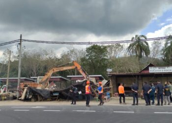 KERJA-kerja meroboh serta membersihkan gerai di tepi jalan Sungai Layang, Rembau dijalankan bagi memberi laluan kepada projek pembangunan persimpangan jalan dan lampu isyarat.-UTUSAN/NOR AINNA HAMZAH.