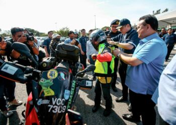 ALEXANDER Nanta Linggi (kanan) memakaikan jaket keselamatan kepada penunggang motosikal sempena Majlis Pelancaran Op Bersepadu dan Kempen Keselamatan Jalan Raya Bersempena Perayaan Tahun Baharu Cina Peringkat Kebangsaan Tahun 2023 di Dengkil. - UTUSAN/ FAISOL MUSTAFA