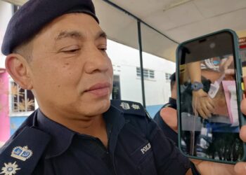 MOHD. Haki Hasbullah menunjukkan gambar pegawainya yang cedera ditetak bekas tentera semasa sidang media di IPD Tanah Merah,Kelantan hari ini-UTUSAN/ROHANA MOHD.NAWI