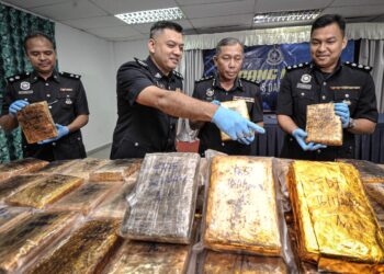 WAN Kamarul Azran Wan Yusof (tengah) menunjukkan ketulan mampat disyaki ganja yang dirampas selepas sidang media KPD Sepang berkaitan tangkapan kes Narkotik dan Bahagian Siasatan Jenayah di IPD Sepang. - UTUSAN/FAIZ ALIF AHMAD ZUBIR