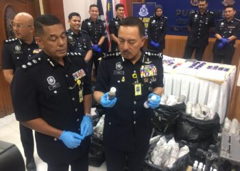 MUHAMAD  Zaki Harun (kanan) menunjukkan ubat batuk yang dirampas pada sidang akhbar di Ibu Pejabat Polis Kontinjen (IPK) Kelantan hari ini. UTUSAN/ROSMIZAN RESDI 