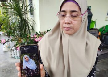 AZIZAH Hussain menunjukkan gambar anaknya, Rabaah Laily yang hilang ketika ditemui pemberita di rumahnya di Juasseh, Kuala Pilah hari ini. -UTUSAN/NOR AINNA HAMZAH.
