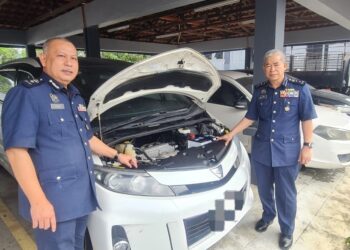 WAN JAMAL Abdul Salam (kanan) menunjukkan salah satu kereta yang dilelong JDKM Kelantan di Kota Bharu, Kelantan hari ini-UTUSAN/IHSAN JDKM