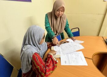 FATIMAH Su (kiri) bersama kakitangannya, Nurfaradilla Roslan, 31, meneliti pelan tapak kawasan seluas 1.006 hektar yang terletak di Sungai Chuchoh, Padang Besar, Perlis. - UTUSAN/ASYRAF MUHAMMAD