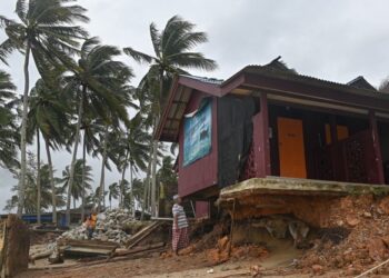 ABDUL Wahab Othman (kanan) melihat keadaan chalet miliknya yang hampir runtuh akibat hakisan pantai di Kampung Tanjung, Batu Rakit, Kuala Nerus, Terengganu. – UTUSAN/PUQTRA HAIRRY ROSLI
