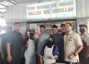 ANWAR Ibrahim dan Aminuddin Harun bergambar bersama pekerja-pekerja Warung Pak Salleh di Kampung Baru Sirusa, Port Dickson, selepas meluangkan masa makan tengah hari di gerai berkenaan hari ini.-UTUSAN/BADRUL HAFIZAN MAT ISA