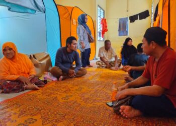 MEK Yam Ahmad (kiri) bersama penduduk Kampung Bendang Perol yang berpindah ke PPS SK Gual To’Deh, Rantau Panjang, Kelantan hari ini.-UTUSAN/YATIMIN ABDULLAH