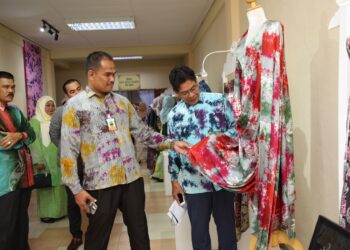 MOHD. Nasir Yusof (kiri) bersama Abdol Samad Nawi melihat batik yang dihasilkan di PPA Machang semasa Program soft Launching Produk Batik PPA Machang 2023 di Pusat Pemulihan Akhlak Machang, Kelantan hari ini.-UTUSAN/KAMARUL BISMI KAMARUZAMAN