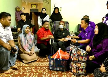 NIK Mohd. Noor Azwan Mustapha (dua kanan) menyampaikan sumbangan kepada Zuraidi Mohamad di Kampung Paloh, Tumpat Kelantan hari ini.- UTUSAN/ FOTO ROSLIZA MOHAMED