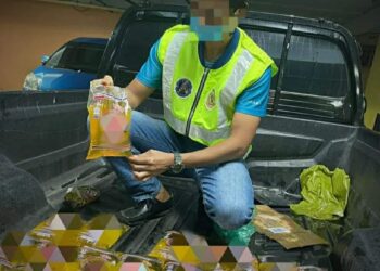 ANGGOTA penguat kuasa KDPN Kelantan menunjukkan minyak masak paket yang telah dibuang oleh penyeludup semasa berusaha melakukan tangkapan di Kampung Delima, Tumpat, Kelantan.-UTUSAN/IHSAN KPDN KELANTAN