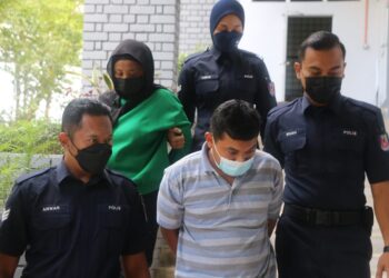 HERMAN Yusof (tengah) dan Hermawati Arif (belakang, baju hijau) dibawa keluar dari Mahkamah Majistret Temerloh setelah didakwa atas kesalahan menggunakan dokumen palsu pembelian motosikal Yamaha Y16ZR di Temerloh, Pahang. - UTUSAN/SALEHUDIN MAT RASAD