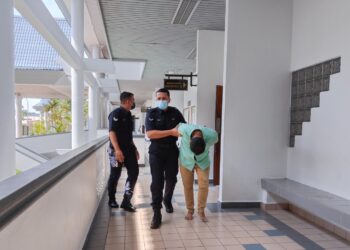 TERTUDUH diiring polis ketika dihadapkan ke Mahkamah Majistret, Ayer Keroh, Melaka. - UTUSAN/MUHAMMAD SHAHIZAM TAZALI