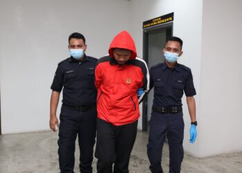 TERTUDUH (tengah) diiringi polis selepas tiba untuk perbicaraan di Mahkamah Majistret Kota Bharu, Kelantan.UTUSAN/KAMARUL BISMI KAMARUZAMAN