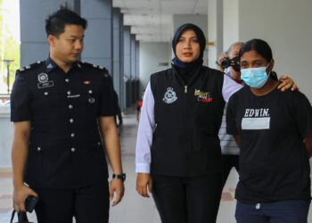 A.N HEMAVATHY (kanan) dibawa ke Mahkamah Majistret Seremban hari ini bagi didakwa atas pertuduhan memperdayakan seorang pesara dengan mengaku sebagai 'Sami Tuhan Kalima' melibatkan kerugian RM8,750, tahun lalu.-UTUSAN/NOR SHAFAWATI YUP.